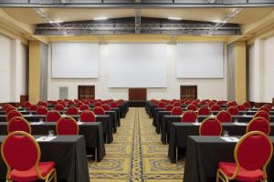 a conference room with tables and chairs and a screen at Rome Marriott Park Hotel in Rome