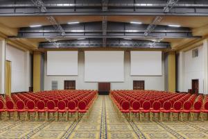 an empty auditorium with red chairs and blank screens at Rome Marriott Park Hotel in Rome