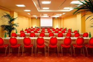 a conference room with red chairs and a podium at Rome Marriott Park Hotel in Rome