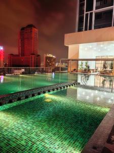 a swimming pool with green lights on top of a building at Chambers KLCC Serviced Suites One in Kuala Lumpur