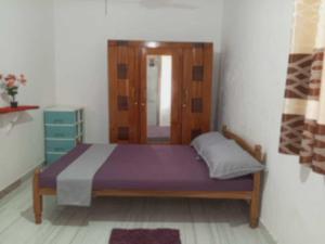 Un dormitorio con una cama con cabecero de madera. en Piya House, en Weligama