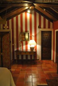 um quarto com uma parede listrada em vermelho e branco em El Hotel De La Villa em Pedraza-Segovia