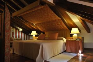 um quarto com uma cama num quarto com tectos em madeira em El Hotel De La Villa em Pedraza-Segovia