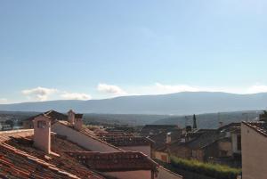 a view of a town with roofs and mountains in the background at El Hotel De La Villa in Pedraza-Segovia