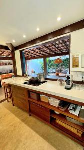 a kitchen with a counter with a large window at Sun House Manguinhos in Búzios