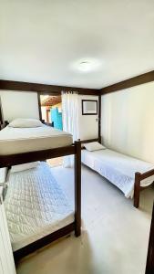 a bedroom with two bunk beds and a window at Sun House Manguinhos in Búzios +32 photos