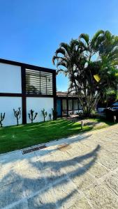 a house with a palm tree in front of it at Sun House Manguinhos in Búzios