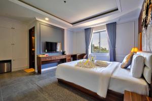 una camera d'albergo con un letto e una televisione di S79 Happy Hotel Phu Quoc a Phu Quoc