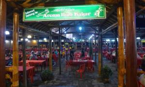 a restaurant with red tables and a green sign at DD Empire Homestay in Jeram
