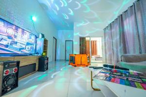 sala de estar con TV y mesa en una habitación en Cool Cool Bangsaray Pool villa, en Sattahip