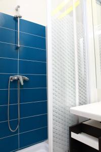 baño con pared azul y ducha en Flat On Andrássy Avenue en Budapest