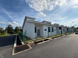 ein weißes Gebäude am Straßenrand in der Unterkunft Temerloh Kenari Homestay in Temerloh