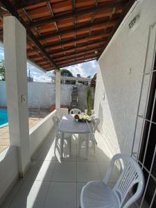 eine Terrasse mit Tisch und Stühlen auf einem Balkon in der Unterkunft Casa Porto de Galinhas in Porto De Galinhas + 11 Fotos