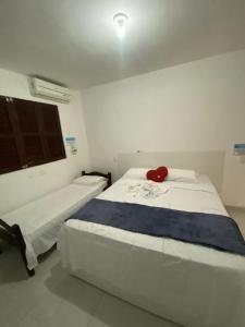 ein Schlafzimmer mit 2 Betten und einem roten Bären auf dem Bett in der Unterkunft Casa Porto de Galinhas in Porto De Galinhas