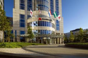 a tall building with flags in front of it at Rotterdam Marriott Hotel in Rotterdam