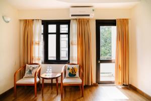 a dining room with two chairs and a table at Mercury Hotel & Apartment in Vung Tau