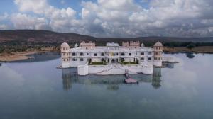 a large white house in the middle of a lake at jüSTa Lake Nahargarh Palace, Chittorgarh in Pārsoli