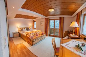 a bedroom with a large bed and a table at Pension Alwin in Lech am Arlberg