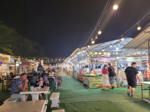 乔木提恩海滩Sorot Darika Jomtien Beach的夜晚，市场里有人坐在桌子旁。