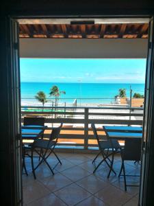 einen Balkon mit Tischen und Stühlen und Strandblick in der Unterkunft Hotel Pousada Maravista in Natal