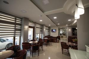 a dining room with tables and chairs in a restaurant at Hotel Olympos in Pýrgos