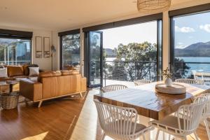 a living room with a table and chairs and a couch at The Moorings at Freycinet Coles Bay in Coles Bay