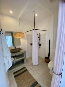 a bathroom with a toilet and a sink and a mirror at Casa de Sassy in Sanur +21 photos