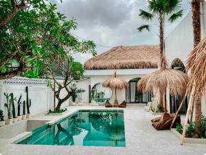 a swimming pool in front of a villa at Casa de Sassy in Sanur