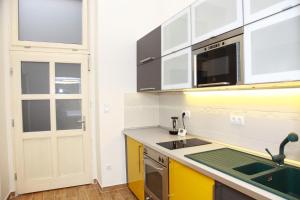 una cocina con armarios blancos y fregadero en Flat On Andrássy Avenue en Budapest