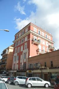 Un edificio con coches aparcados en un estacionamiento. en Casa Vacanze Zio Gionni, en Roma