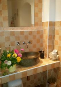 La salle de bains est pourvue d'un lavabo avec un vase de fleurs sur un comptoir. dans l'établissement Villa Mont des Oliviers CITRA-8055LT-1805 e 1807, à Sanremo