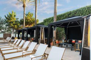 a row of white chairs and tables and palm trees at San Diego Marriott Del Mar in San Diego
