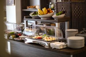a buffet with plates of food and bowls of fruit at Hotel Marienthal Garni in Hamburg