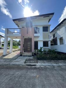 a white house with the sun in the sky at Denelle's fab house staycation in Lucap +3 photos