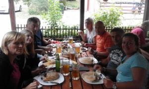 a group of people sitting at a table eating food at Rafting Campsite Stari Dud in Foča