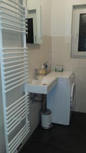 a white bathroom with a sink and a mirror at Appartement Matthias in Vörstetten