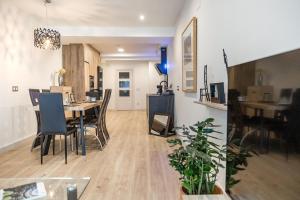 a dining room and living room with a table and chairs at Espacioso apartamento a 9 min playa in Gijón