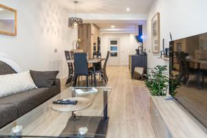 ein Wohnzimmer mit Sofa und Tisch in der Unterkunft Espacioso apartamento a 9 min playa in Gijón