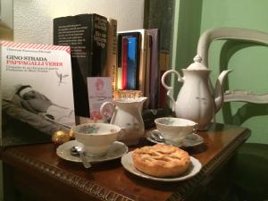 a table with books and tea cups and a pastry on it at La Stagione dell'Arte in Camaiore +21 photos