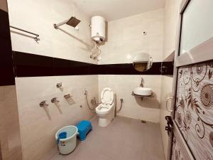 a small bathroom with a toilet and a sink at Sadyal Hotel And Restaurant in Tīra Sujānpur +7 photos