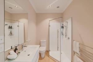 a white bathroom with a shower and a toilet at Lake Tekapo 1BR Retreat - The Lakeview Hideaway in Lake Tekapo