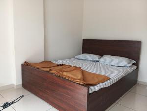 a bed with a wooden bed frame in a room at Whispering Wind Homestay in Kolhapur
