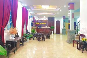a lobby with tables and chairs in a building at OPA HOTEL HUE in Hue