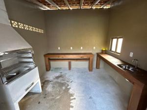 an empty room with a table and a sink at Casa privativa com piscina na Praia da Ferrugem duas quadras mar REF 100 in Garopaba