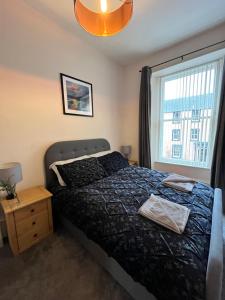 a bedroom with a bed and a window at TheFlatInJed in Jedburgh