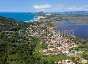 an aerial view of a town next to a lake at Casa privativa com piscina na Praia da Ferrugem duas quadras mar REF 100 in Garopaba +23 photos