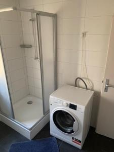 a washing machine in a bathroom with a shower at Monteurpension Haus Monika in Marktheidenfeld