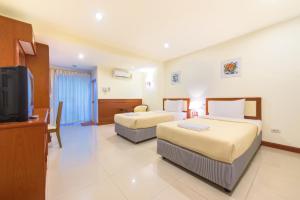 Habitación de hotel con 2 camas y TV de pantalla plana. en Nuntiya Terrace en Udon Thani