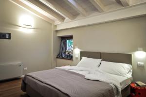 a bedroom with a bed with white sheets and a window at Belvivere Suites in Sona