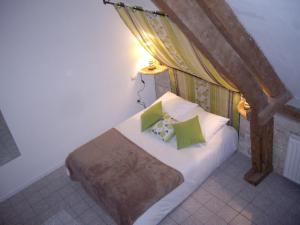 - une chambre avec un lit et des oreillers verts dans l'établissement Auberge De La Luzerne, à Bernières-sur-Mer